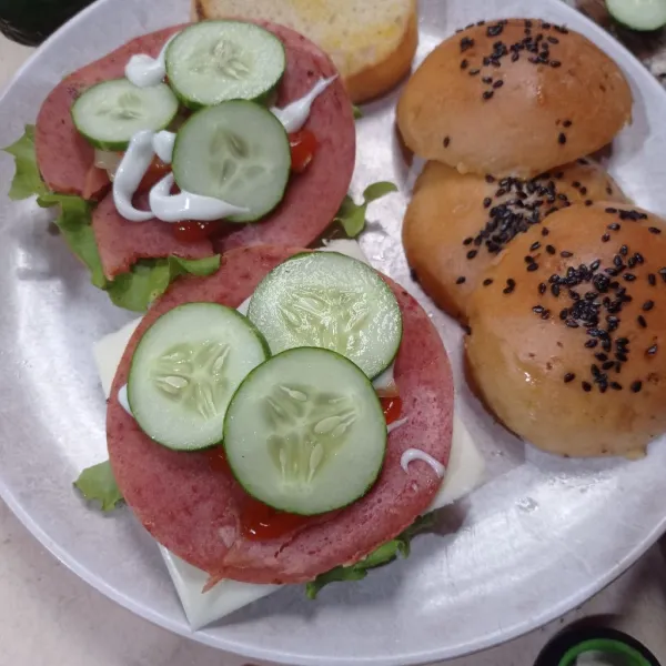 Lalu tata selada, keju slice, smoke beef, beri saus sambal dan mayones terakhir irisan timun.