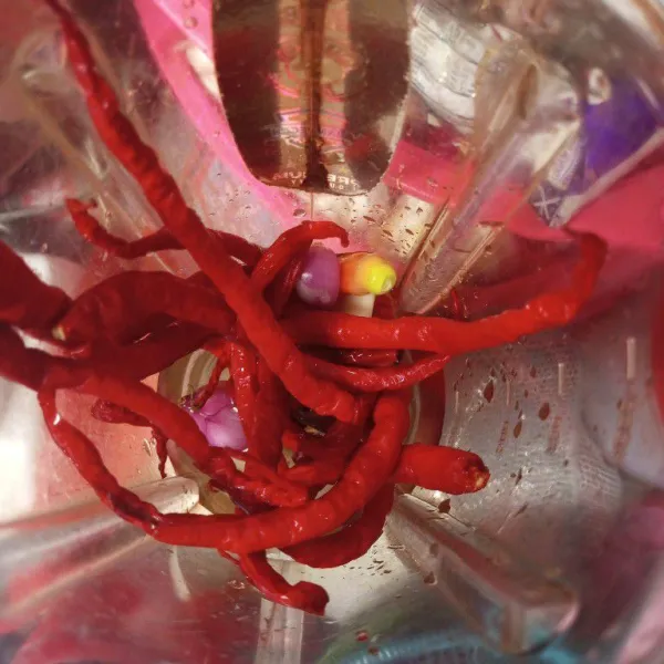 Haluskan cabai, bawang merah, dan bawang putih.