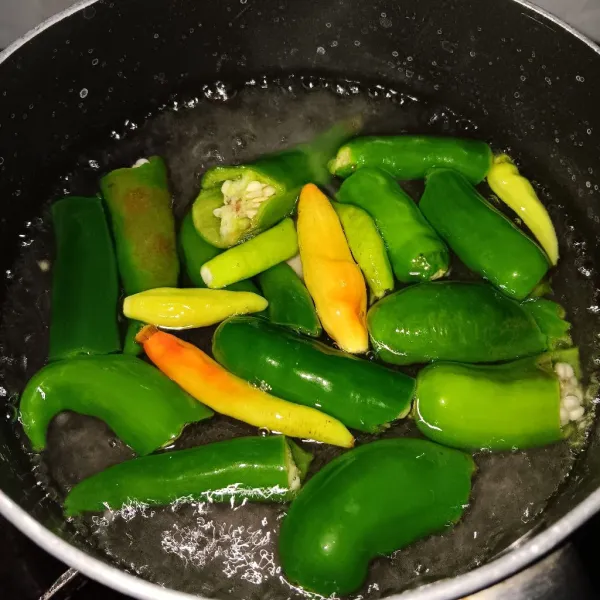 Rebus air tambahkan sedikit garam. Setelah mendidih rebus cabe hijau besar dan cabe rawit dan bawang putih. Setelah cukup layu tiriskan.
