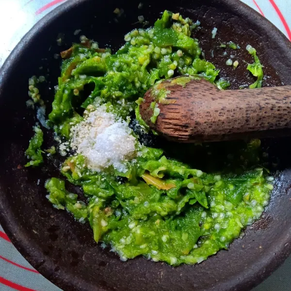 Uleg halus bawang putih, uleg kasar cabe. Tambahkan garam, kaldu jamur, penyedap dan sedikit gula. Uleg ringan agar tercampur.