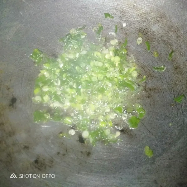 Panaskan minyak goreng lalu tumis irisan daun bawang sampai layu.