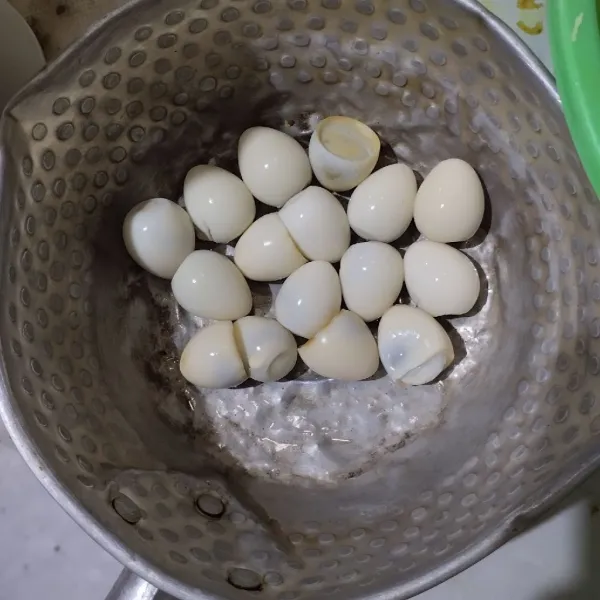 Kupas telur puyuh yang sudah direbus.