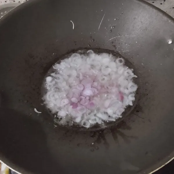 Tumis bawang merah dalam minyak panas hingga harum.