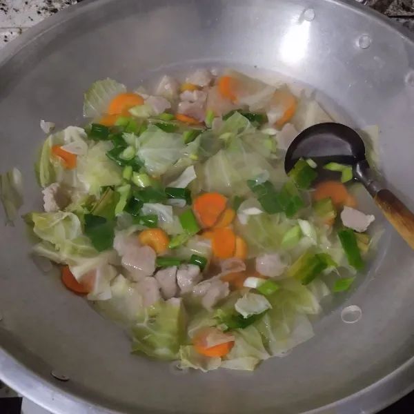 Masukkan daun bawang, garam, lada, dan kaldu bubuk. Masak hingga mendidih, tes rasa.