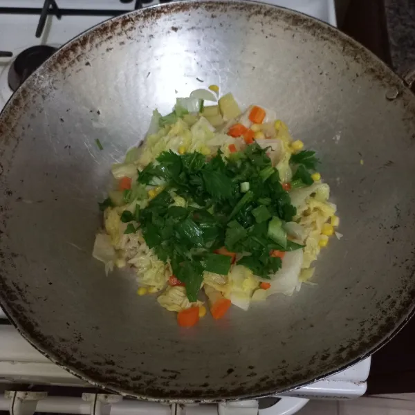 Tambahkan irisan bawang daun dan seledri, masak hingga matang