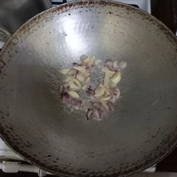 Tumis irisan bawang putih dan bawang merah hingga harum
