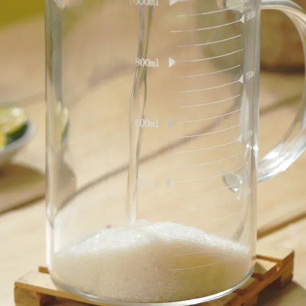 Larutkan gula dengan 100 ml air hangat hingga gula larut.