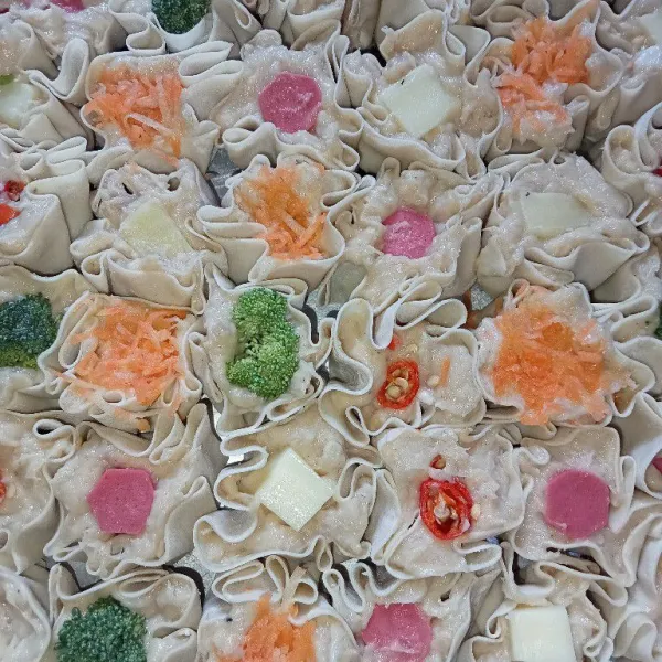 Letakkan dimsum di atas kukusan, tambahkan topping di atas dimsum. Kemudian, kukus dimsum 25 menit dan siap disajikan!