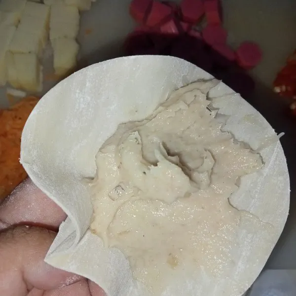 Ambil kulit dimsum, tambahkan adonan di dalam kulit pangsit, lalu tutup rapat.