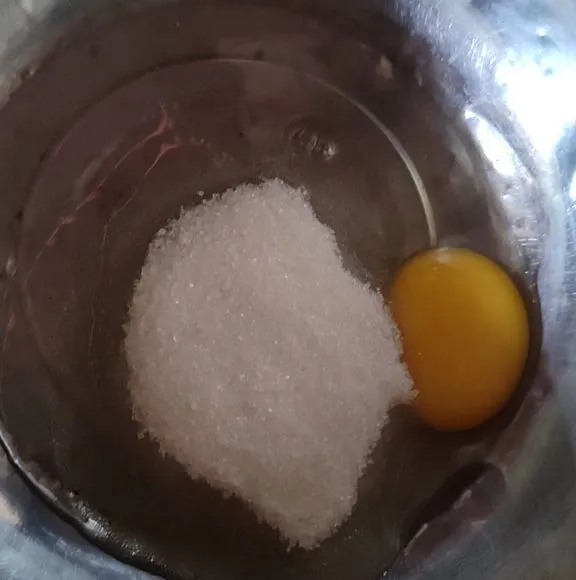 pecahkan 1 butir telur lalu aduk bersama 4 sdm gula pasir hingga gula larut