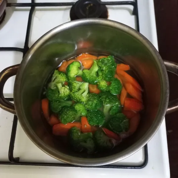 Didihkan air pada panci, masukan irisan wortel masak beberapa saat lalu masukan brokoli, matikan kompor