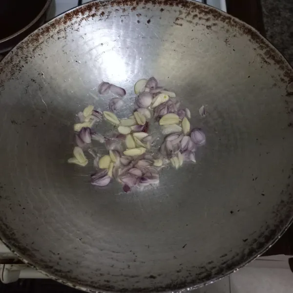 Tumis irisan bawang merah dan bawang putih hingga harum