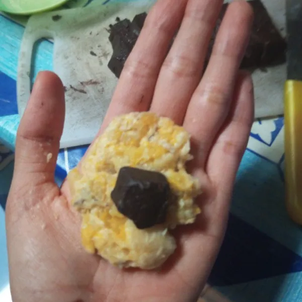 Pipihkan adonan lalu beri isian coklat batang, bentuk bulat.