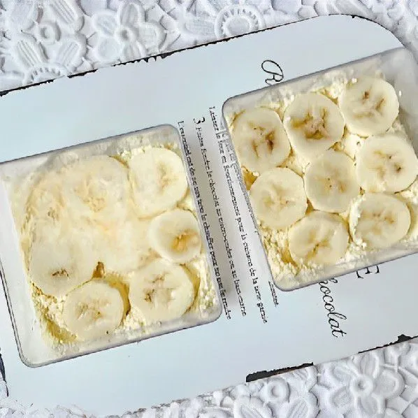 Tata irisan pisang di atas lapisan yogurt, lalu tambahkan yogurt.