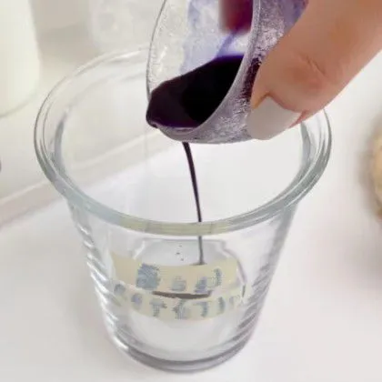 Tuangkan sirup bunga telang ke dalam gelas saji.