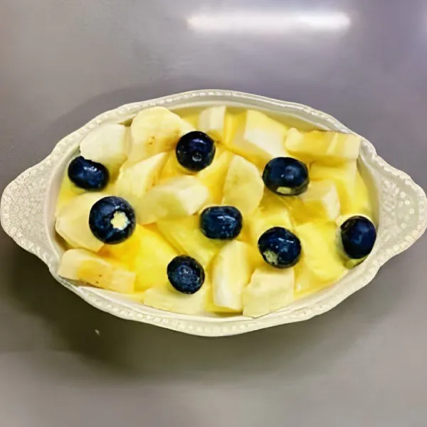 Tambahkan blueberry di atas irisan pisang. Tuang campuran susu dan telur secara merata di atas roti dan buah