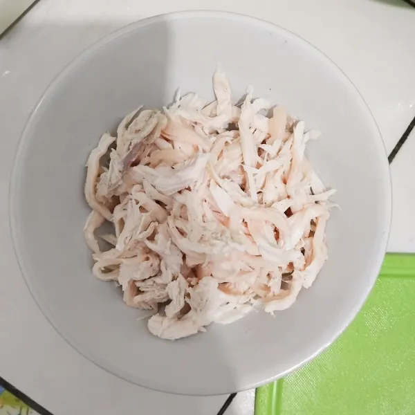 Rebus ayam dengan 1/2 sdt garam, 1/2 sdt lada bubuk, 1 lembar daun salam. Angkat, tiriskan, suwir suwir