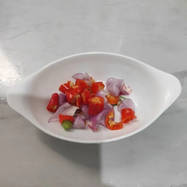 Siapkan wadah, masukkan bawang merah dan cabe rawit.