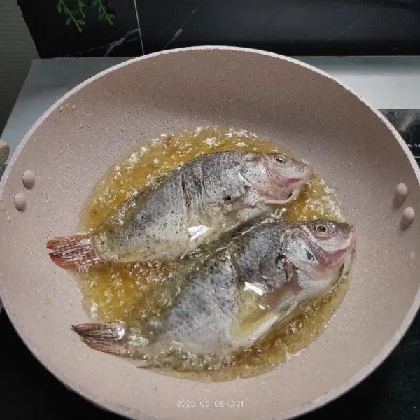 Panaskan minyak, goreng ikan hingga setengah matang. Angkat dan tiriskan.