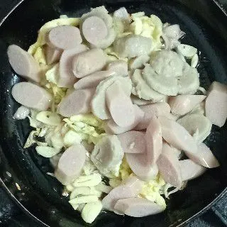 Masukkan sosis, bakso, dan telur orak-arik. Aduk rata dan tumis sebentar hingga sosis cukup matang.