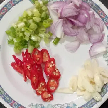 Iris bawang merah, bawang putih, dan bawang prei. Iris serong cabai merah besar.