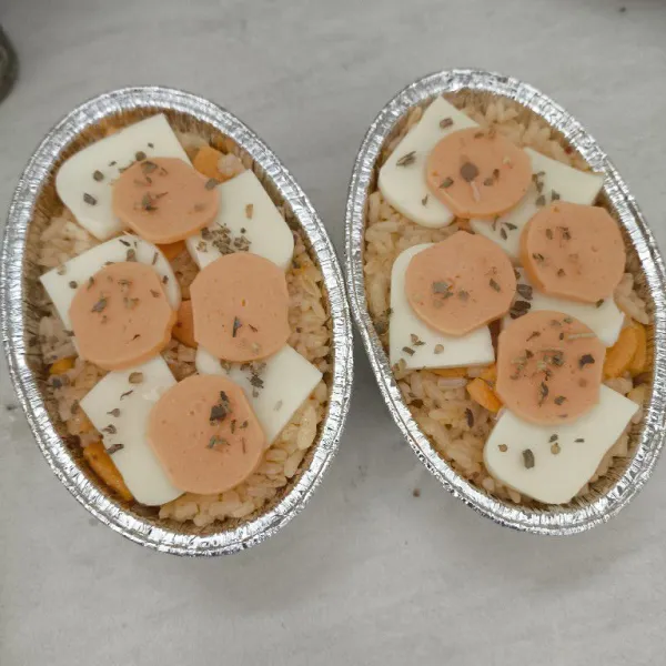 Topping dengan keju Mozzarella dan irisan sosis, taburi atasnya dengan bubuk oregano.