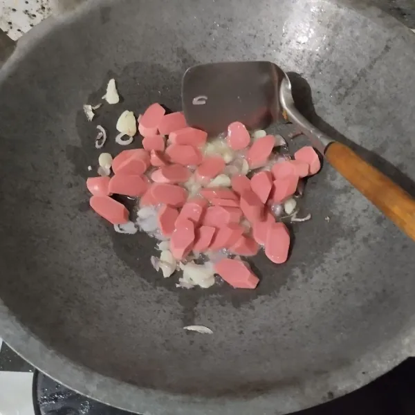 Masukkan sosis, aduk selama satu menit.