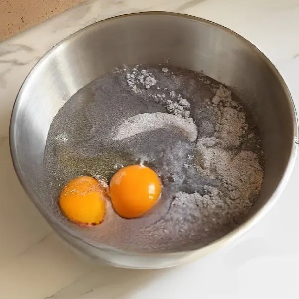 Campurkan 180 gr tepung beras hitam, 140 ml air, 3 gr ragi instan, dan 2 butir telur ke dalam mangkuk. Aduk rata hingga adonan tercampur merata