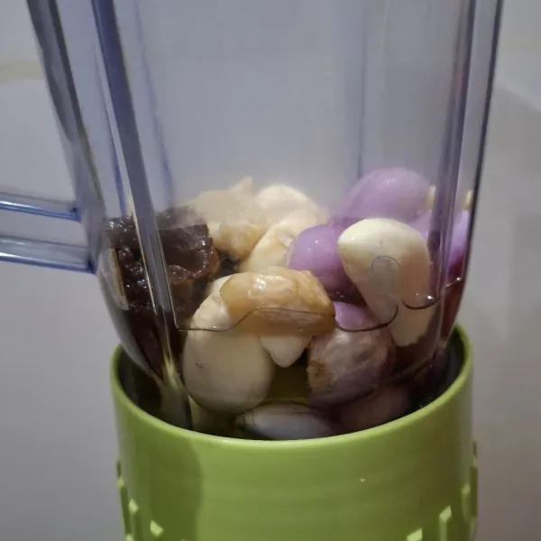 Haluskan bawang merah, bawang putih, gula merah, air asam, dan kemiri menggunakan minyak secukupnya.