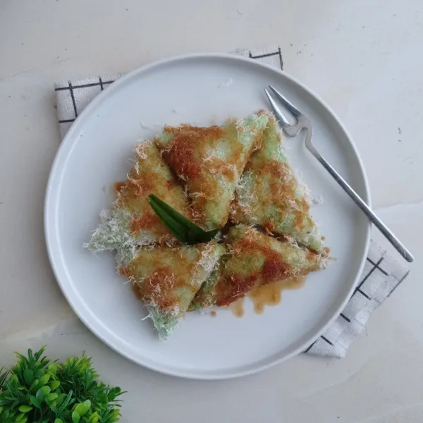 Buka kue lupis dari daunnya, lalu gulingkan ke kelapa parut. Tata pada piring, siram dengan saus gula merah. Sajikan!