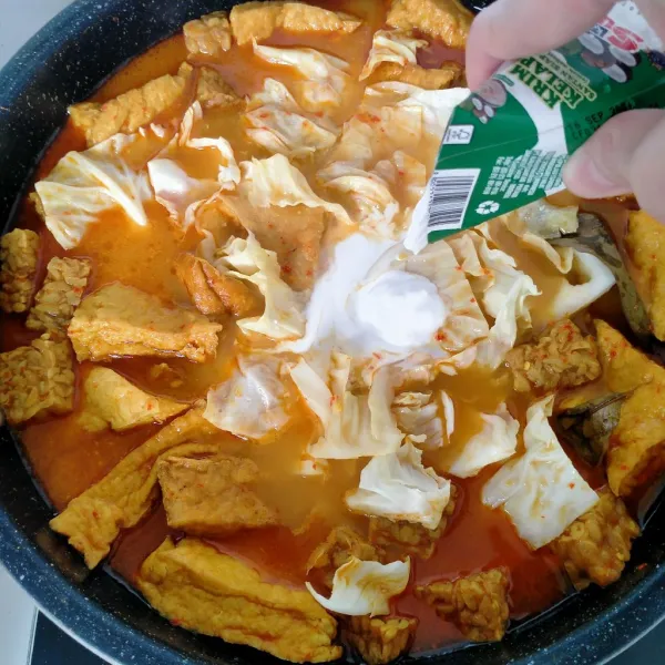 Tambahkan santan instan, lalu aduk sampai rata dan masak hingga mendidih kembali sambil diaduk-aduk. Angkat dan sajikan.