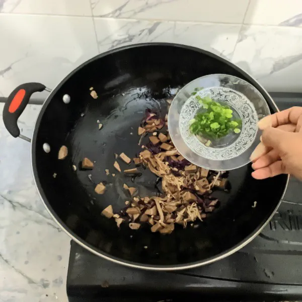 Masukkan irisan daun bawang, masak sebentar.