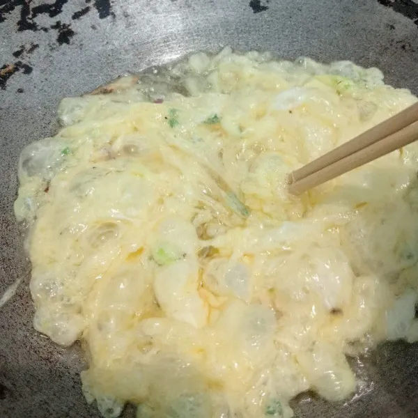 Panaskan penggorengan dengan minyak yang banyak (⅓ alat masak). Jika sudah panas, tuang ½ dari kocokan telur sambil diaduk dengan sumpit agar tercipta tekstur yang berenda.