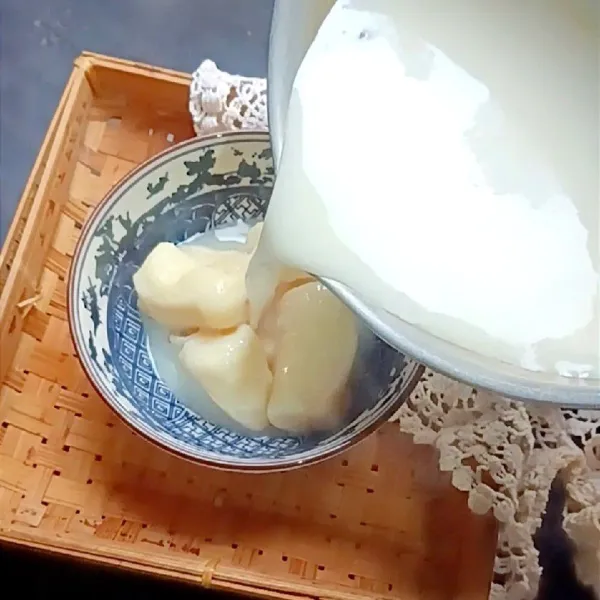 Siapkan tape dalam mangkuk, lalu tuang kuah susu jahenya.