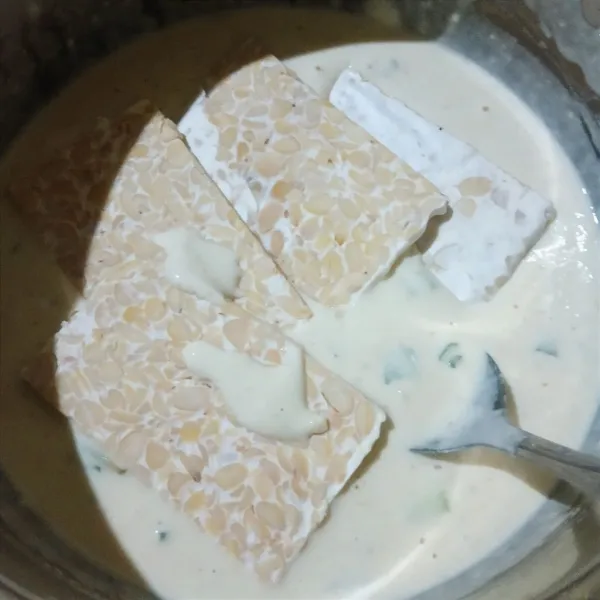Celupkan irisan tempe dalam adonan tepung.