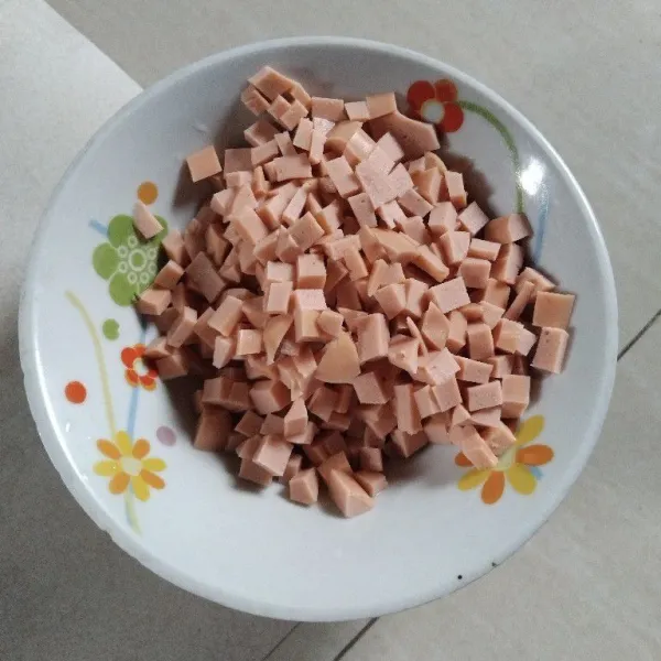 Potong dadu kecil sosis. Iris tipis daun bawang.