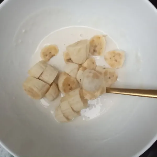 Campur tepung dan air secukupnya, buat adonan dengan kekentalan sedang, masukkan pisang dan aduk rata.