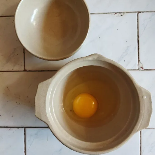 Pecahkan telur ke dalam wadah keramik atau ttukbaegi (mangkuk korea).