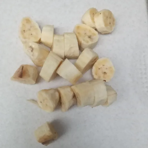 Kupas pisang, lalu potong-potong.