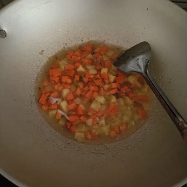 Masukkan kentang, wortel, dan air. Tunggu hingga setengah matang.