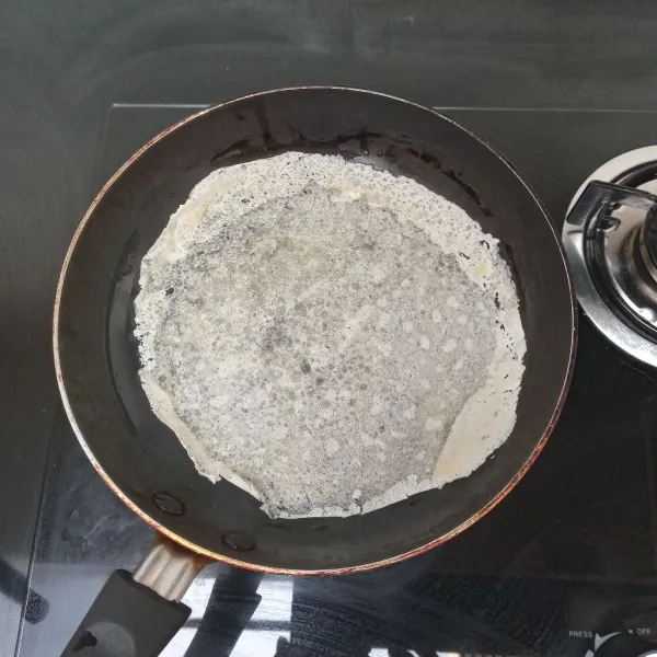 Oles wajan dengan sedikit mentega, masukkan 2 lbr kulit lumpia, gunakan api kecil.