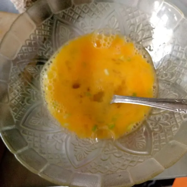 Kocok telur, garam, dan susu. Tambahkan irisan daun bawang.