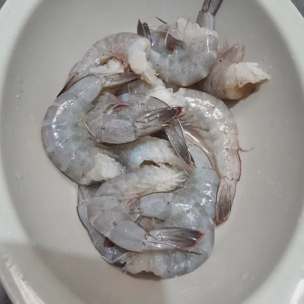 Cuci bersih udang, lalu buang kepalanya, lumuri dengan asam dan garam.