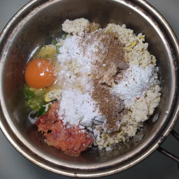 Masukkan tahu yang sudah dihaluskan, bumbu halus, daun bawang iris, telur ayam, bumbu tabur, dan tepung beras. Aduk hingga rata.