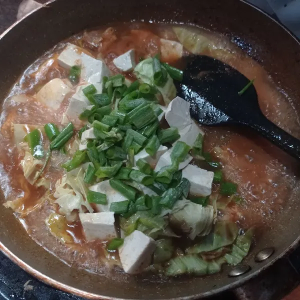 Masukkan potongan tahu, kol, dan daun bawang. Masak sampai tahu matang.