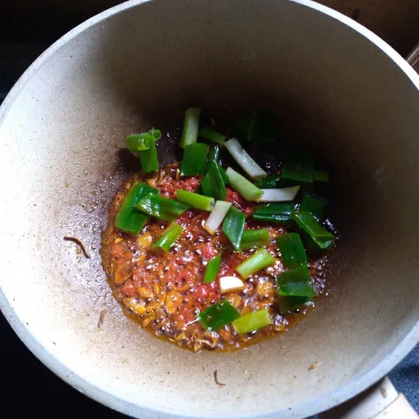 Masukkan daun bawang, tumis hingga layu.