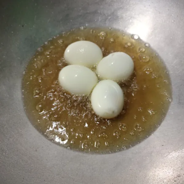 Goreng telur yang sudah direbus hingga berkulit.