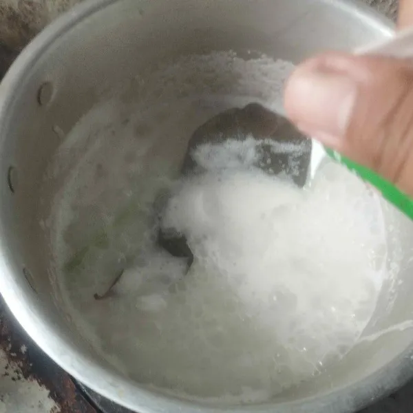 Masukkan daun salam dan serai geprek. Lalu, tuang santan dan beri garam. Aduk terus hingga air menyusut dan nasi aron matang.