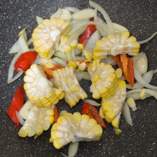 Masukkan jagung, kemudian aduk sebentar.