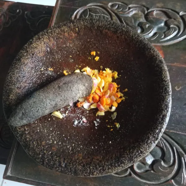 Uleg halus kunyit, jahe, bawang merah, dan sebagian bawang putih.